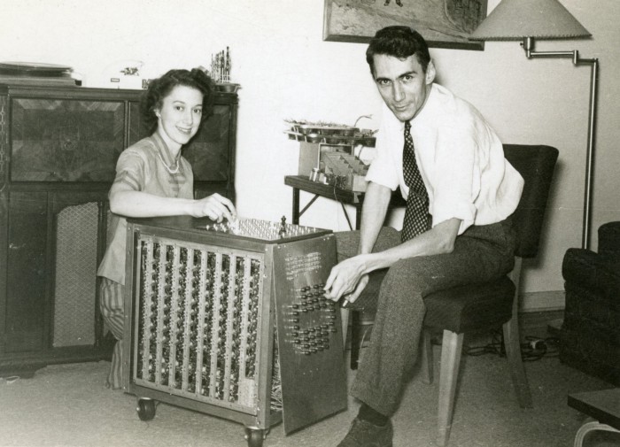 Claude Shannon and his wife seated next to his chess-playing machine